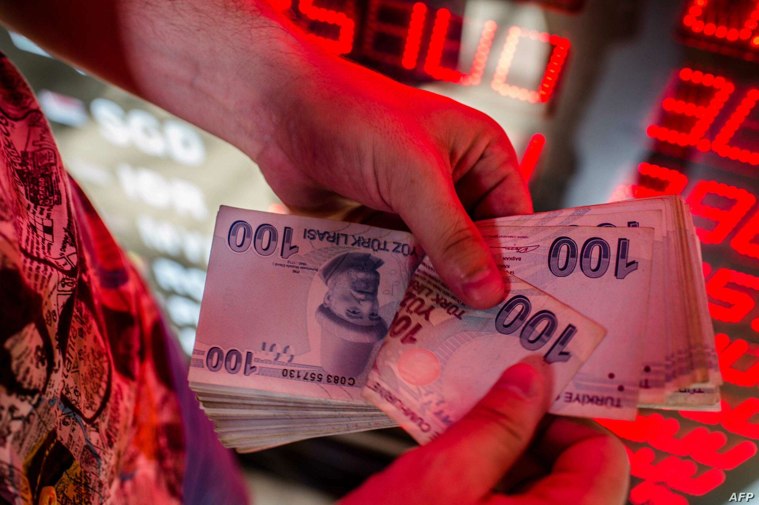 صراف يعد الأوراق النقدية بالليرة التركية في مكتب صرافة في إسطنبول - إنترنت