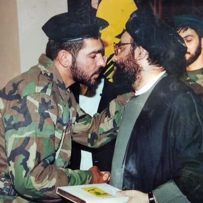 حسن محسن المعروف بـ"ولاء عيتيت" مع صور حسن نصرالله الأمين العام لـ "حزب الله" اللبناني - إنترنت