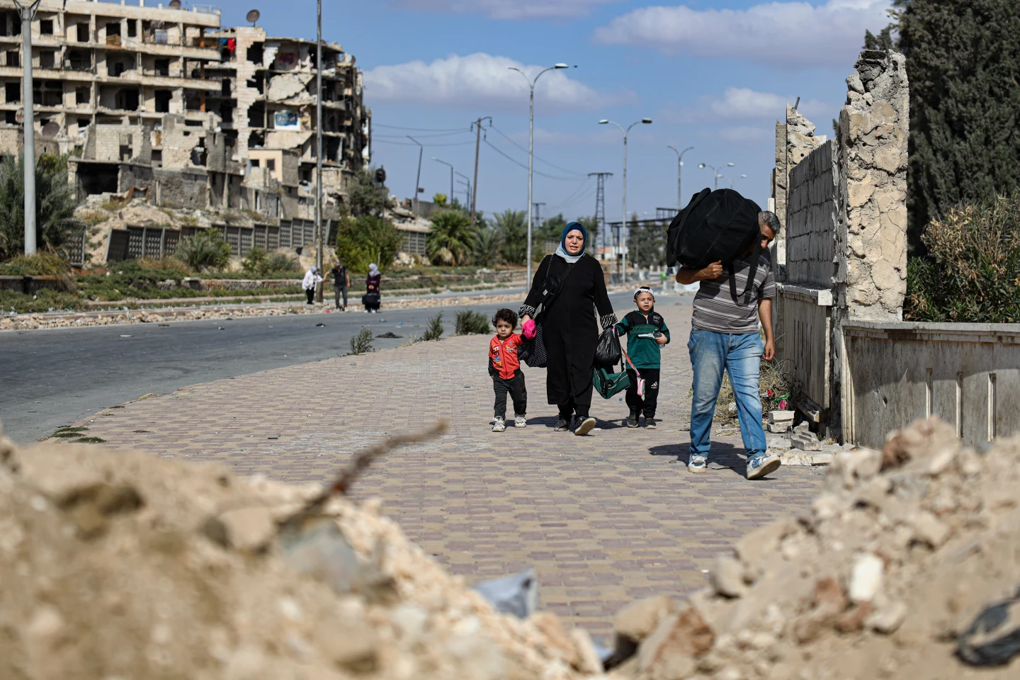 سكان يغادرون حيي الشيخ مقصود والأشرفية في حلب، سوريا، الثلاثاء 7 أكتوبر/تشرين الأول 2025، عقب اشتباكات ليلية بين قوات الحكومة السورية وقوات سوريا الديمقراطية ذات القيادة الكردية. (صورة من أسوشيتد برس/عمر البام)
