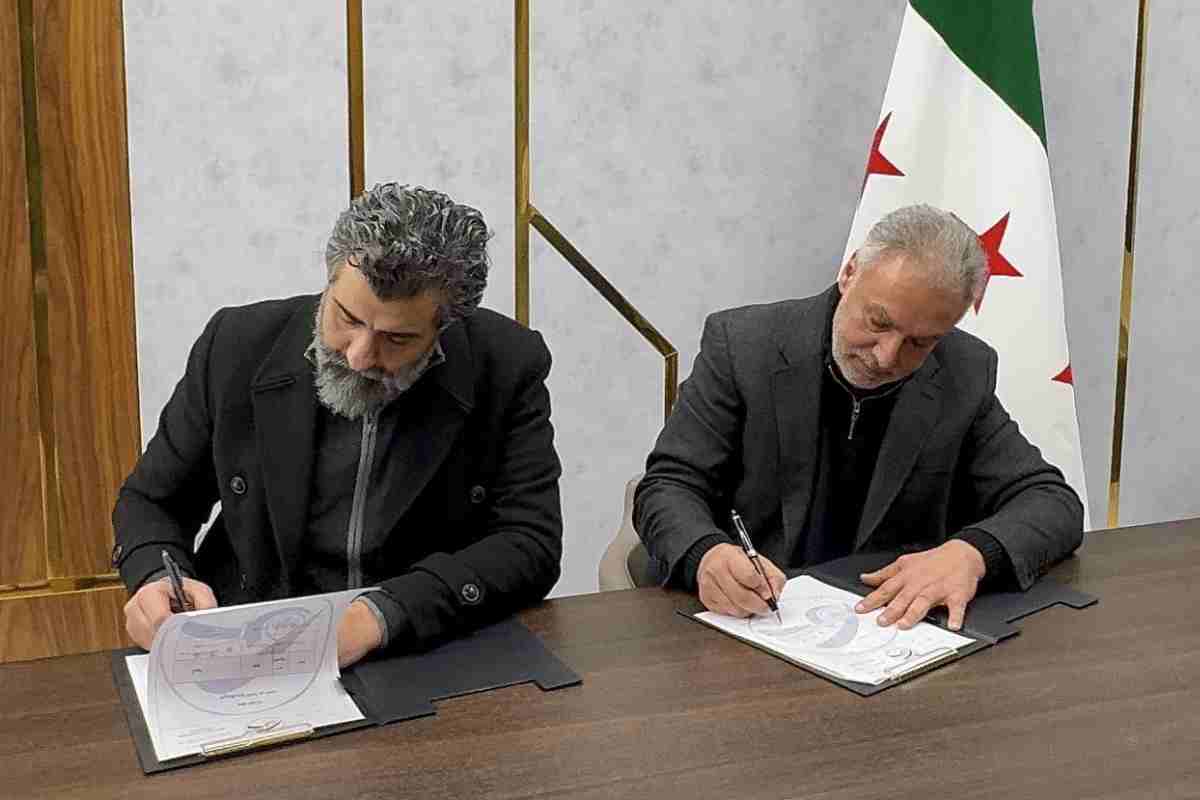 محمد حمشو يوقع اتفاقا مع عضو لجنة مكافحة الكسب غير المشروع رامي صوان، المعروف باسم “الشيخ أبو زيد”.