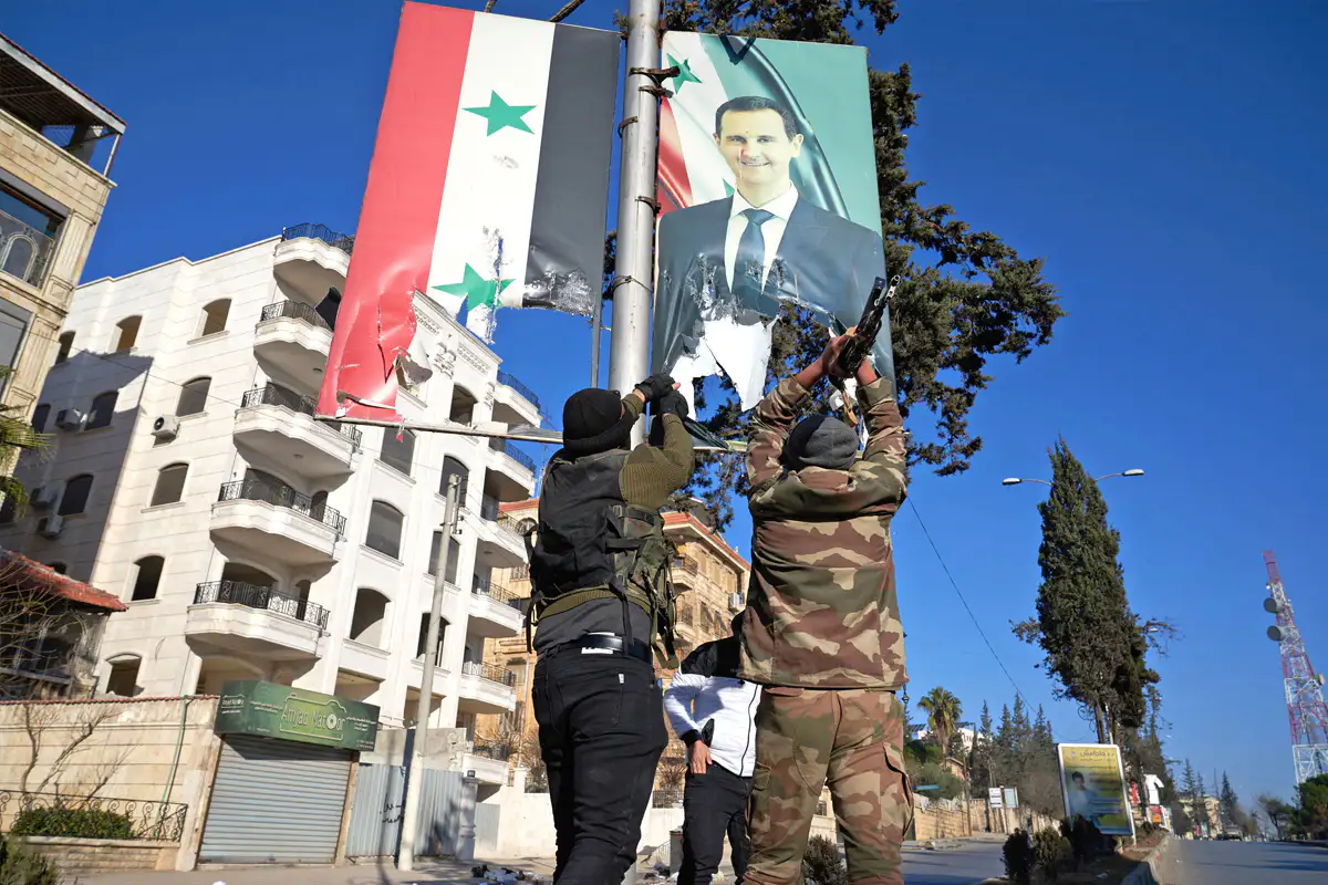 مقاتلون يزيلون صورة بشار الأسد في حلب 30 تشرين الثاني/نوفمبر 2024 "EPA-EFE"